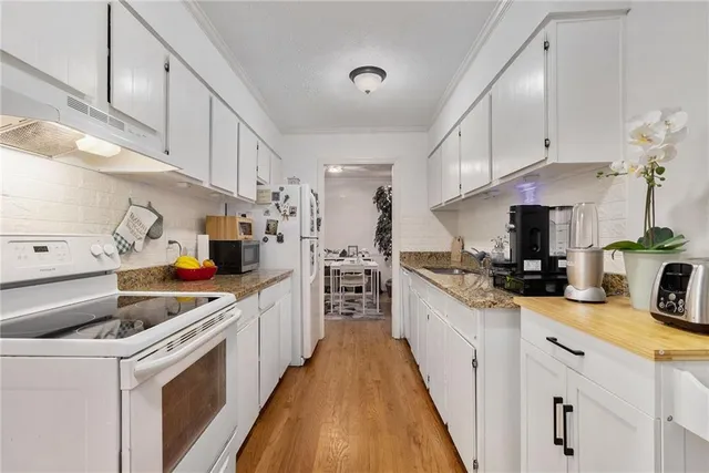 a kitchen with a sink a stove and cabinets