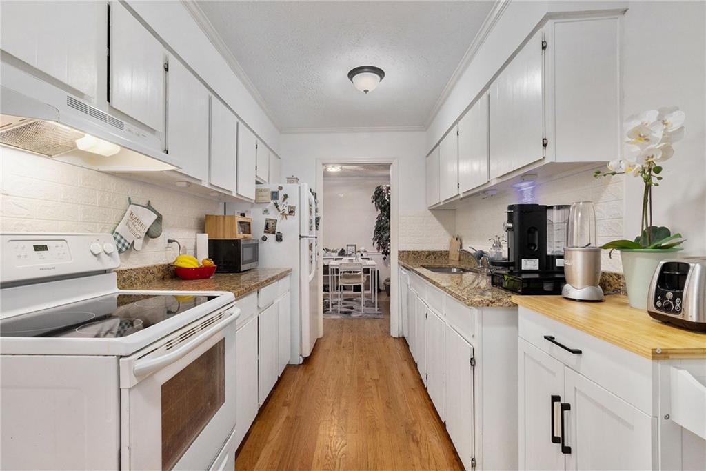 725 Dalrymple Road, Unit 3H Atlanta, GA 30328 - Photo 8 of 17 a kitchen with a sink a stove and cabinets