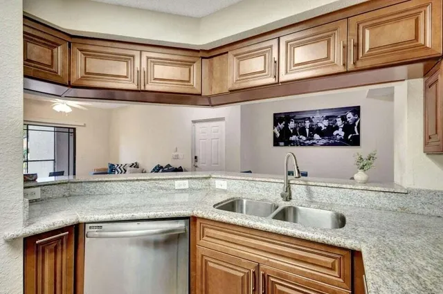 a kitchen with stainless steel appliances granite countertop a sink a stove and cabinets