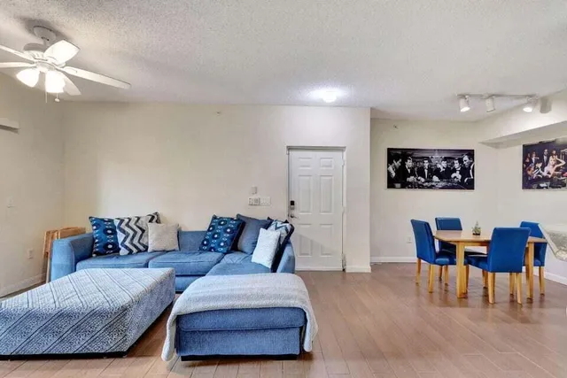 a living room with furniture and a dining table with bookshelf