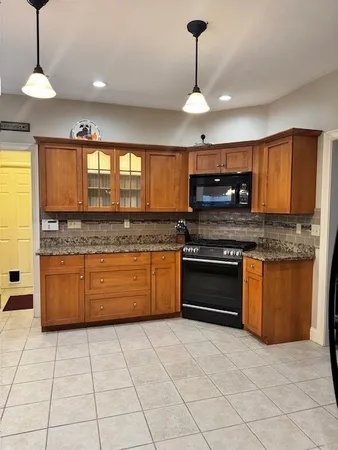 a kitchen with stainless steel appliances granite countertop a stove a sink and a microwave