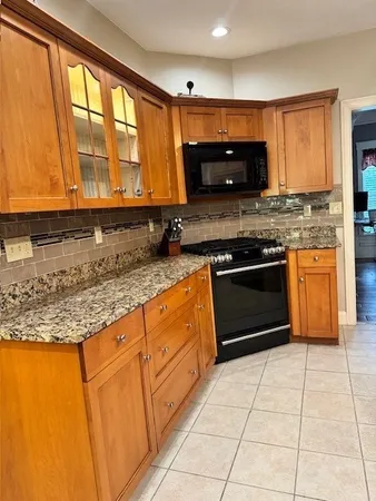 a kitchen with stainless steel appliances granite countertop a stove a sink and a microwave