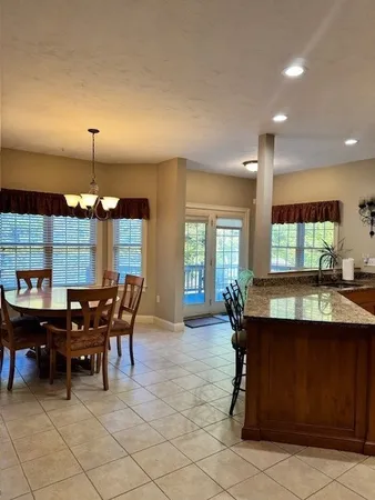 a kitchen with a dining table chairs and granite counter tops