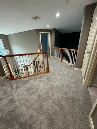 a view of staircase with lots of frames on wall and windows