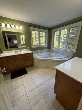 a spacious bathroom with a sink a large mirror and a bathtub