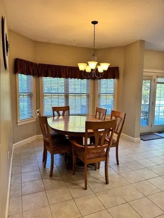 a view of a dining room and chandelier with furniture and window