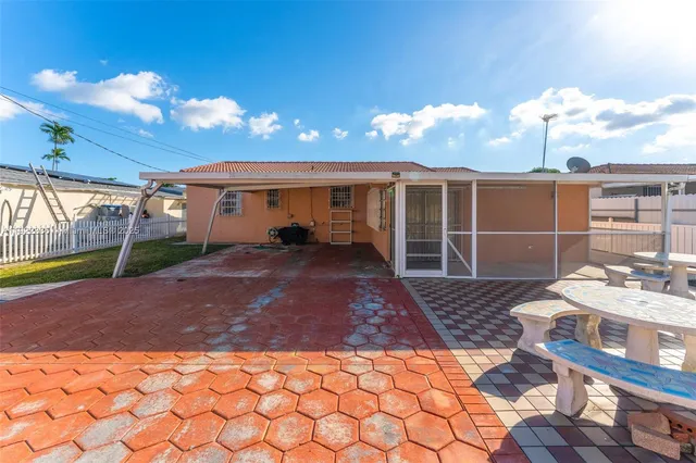 a view of a house with backyard and sitting area