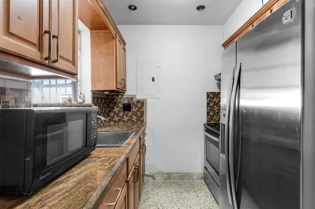 a kitchen with stainless steel appliances granite countertop a refrigerator and a sink