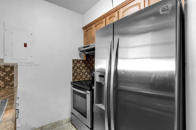 a metallic refrigerator freezer sitting in a kitchen