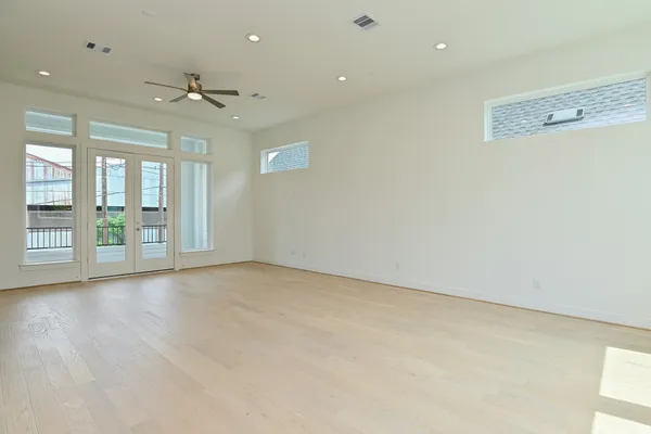 an empty room with wooden floor and windows