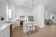 a kitchen with stainless steel appliances granite countertop a refrigerator a sink a stove and white cabinets