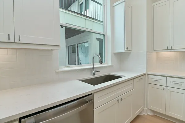 a large white kitchen with a large window