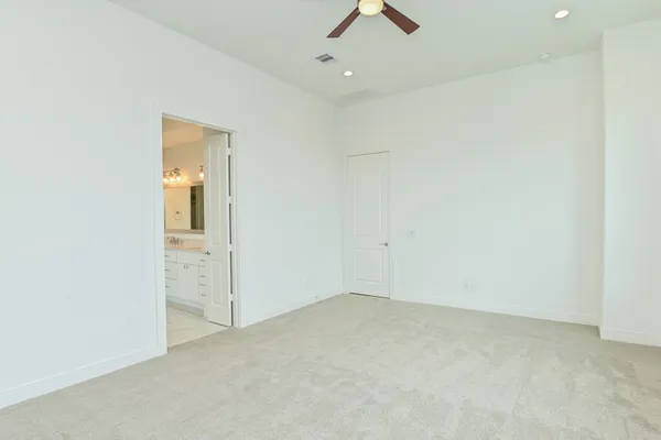 an empty room with closet and a chandelier fan
