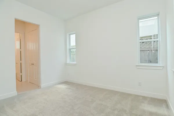an empty room with windows and closet