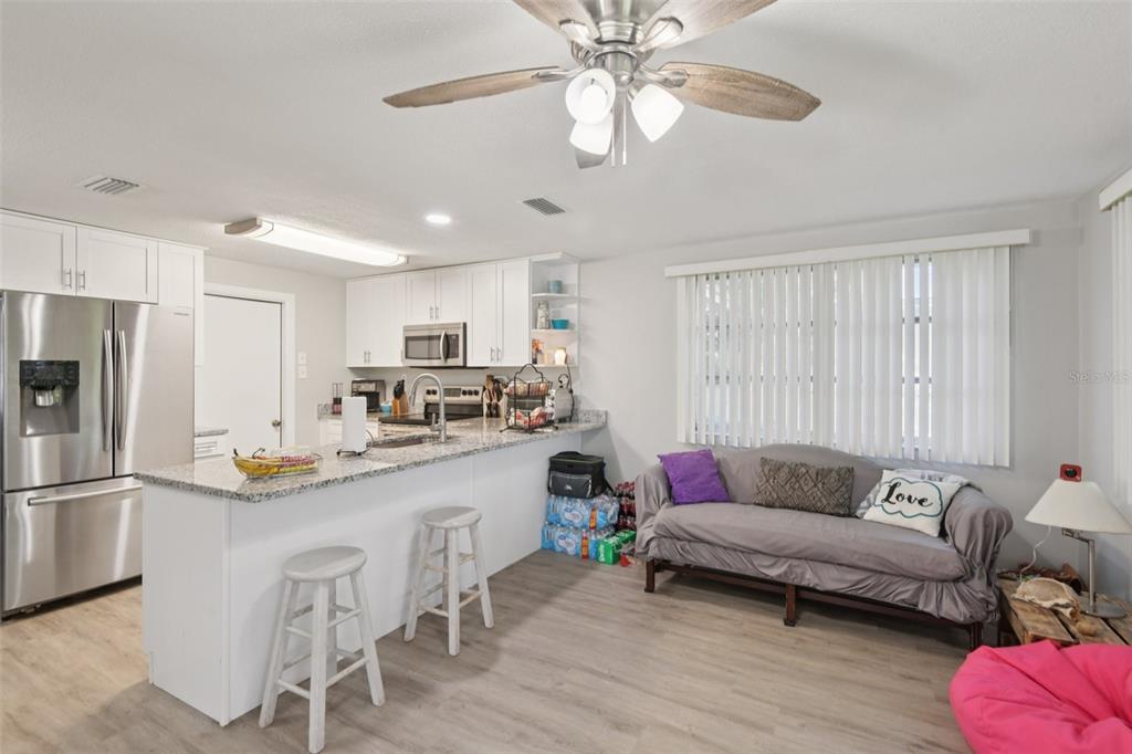 7102 Cherry Laurel Drive Port Richey, FL 34668 - Photo 11 of 39 a living room with stainless steel appliances furniture a chandelier and a dining table