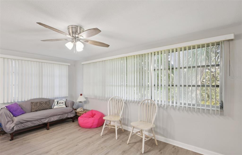 7102 Cherry Laurel Drive Port Richey, FL 34668 - Photo 12 of 39 a living room with furniture and a chandelier