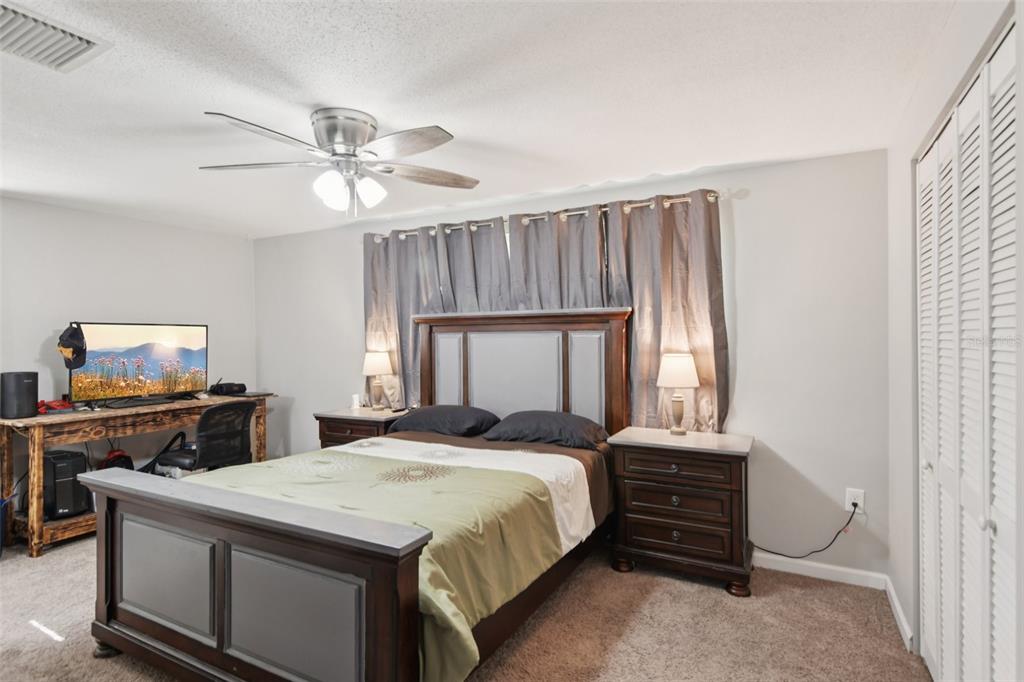 7102 Cherry Laurel Drive Port Richey, FL 34668 - Photo 15 of 39 a bedroom with a bed and a flat screen tv