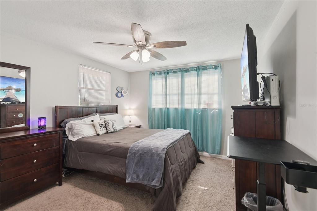 7102 Cherry Laurel Drive Port Richey, FL 34668 - Photo 20 of 39 a bedroom with a bed and a flat tv screen on dresser