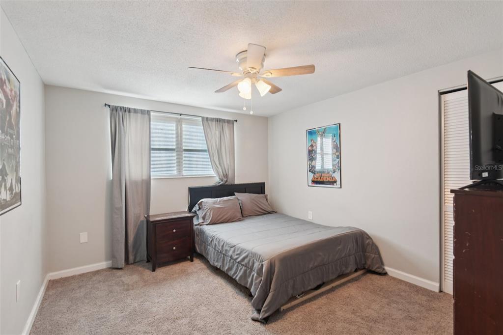 7102 Cherry Laurel Drive Port Richey, FL 34668 - Photo 23 of 39 a bedroom with a large bed and a chandelier
