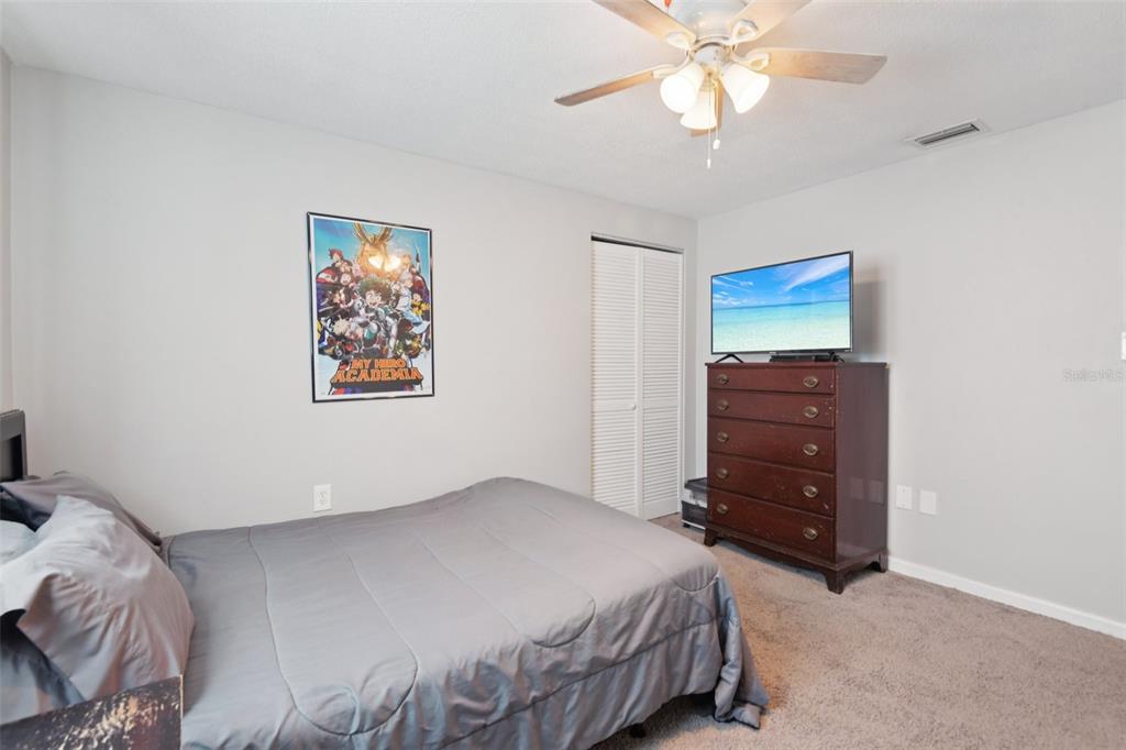 7102 Cherry Laurel Drive Port Richey, FL 34668 - Photo 24 of 39 a bedroom with a bed and a chandelier