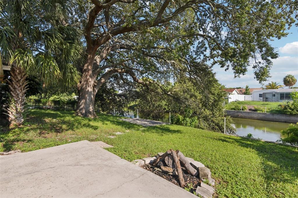 7102 Cherry Laurel Drive Port Richey, FL 34668 - Photo 30 of 39 a view of a lake with a yard and large trees