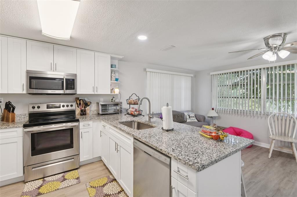 7102 Cherry Laurel Drive Port Richey, FL 34668 - Photo 7 of 39 a kitchen with granite countertop stainless steel appliances a stove microwave and sink