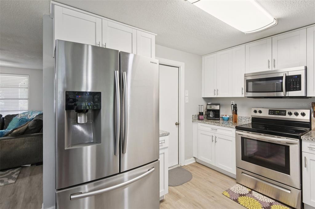 7102 Cherry Laurel Drive Port Richey, FL 34668 - Photo 9 of 39 a kitchen with stainless steel appliances a refrigerator stove and microwave