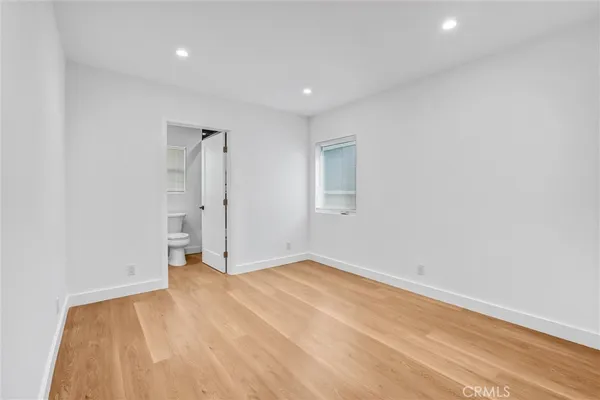a view of a room with wooden floor and a bathroom