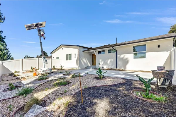 a view of a white house with a yard and a large tree
