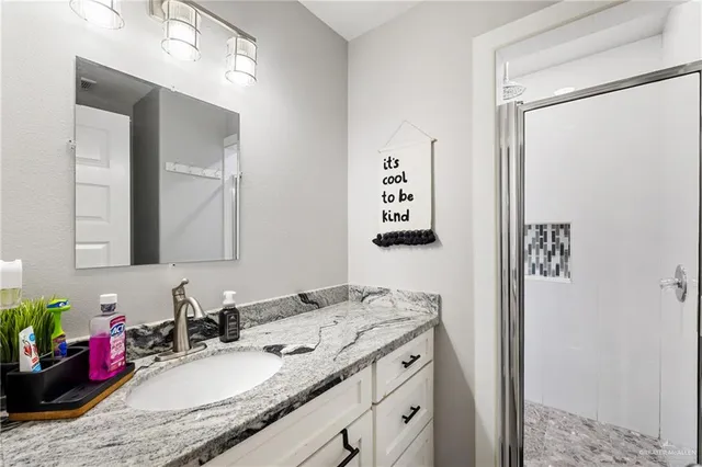 a bathroom with a granite countertop sink mirror and vanity