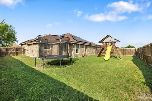 a view of a house with a big yard and a fountain