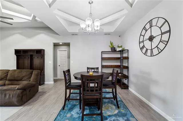 a view of a dining room with furniture and a chandelier