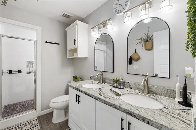 a bathroom with a granite countertop toilet sink and mirror