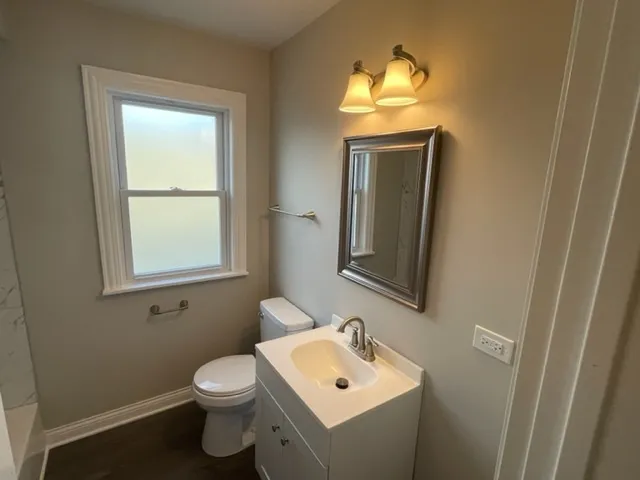 a bathroom with a toilet sink and mirror