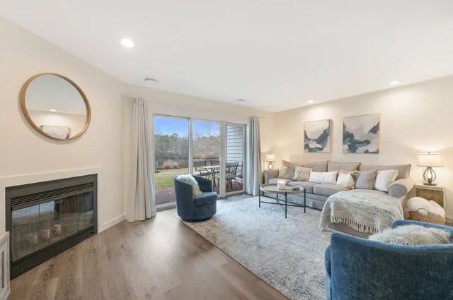 a living room with furniture a fireplace and a floor to ceiling window