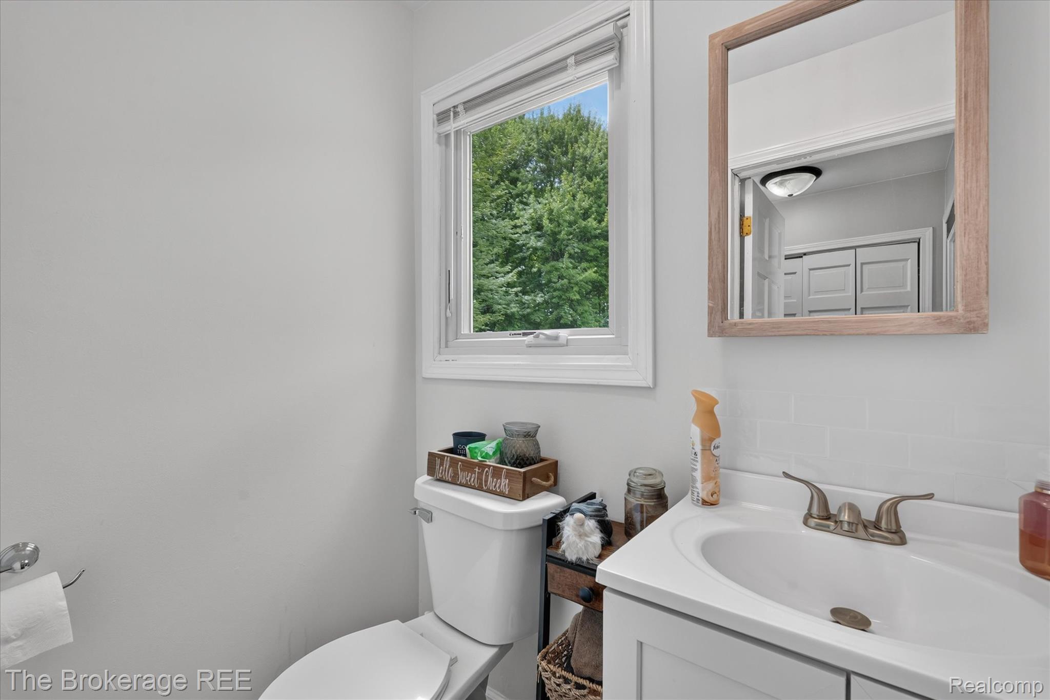 13269 North Genesee Road Clio, MI 48420 - Photo 31 of 67 Bathroom featuring a white vanity with integrated sink, bronze-finish faucet, subway tile backsplash, and a framed mirror