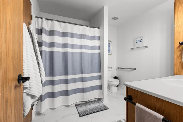 a bathroom with a toilet and a shower curtain