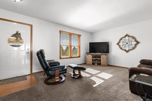 a living room with furniture a flat screen tv and a window