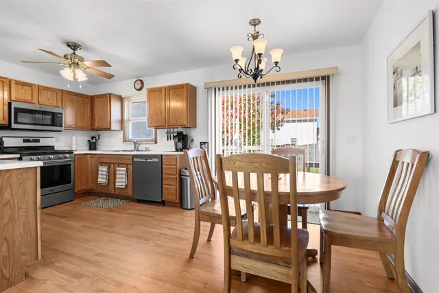 a view of a dining room with furniture a chandelier and wooden floor