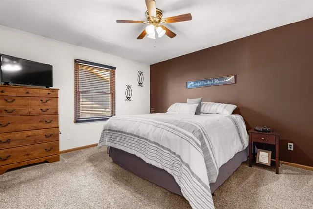 a spacious bedroom with a bed and a flat screen tv