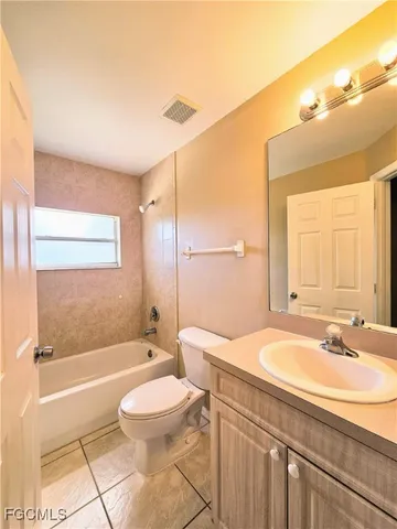 a bathroom with a sink a toilet a mirror and bathtub