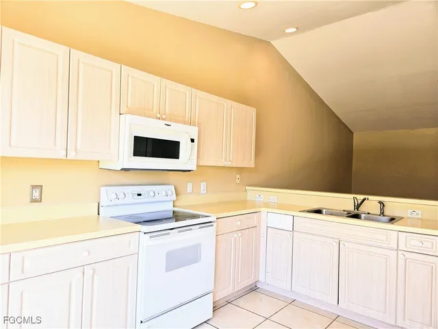a kitchen with white cabinets sink and white appliances