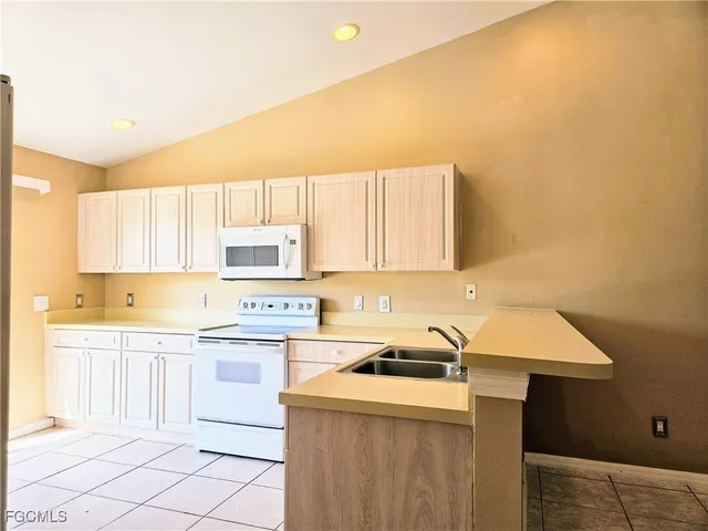a kitchen with a sink a stove and cabinets