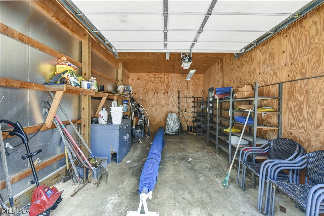 301 Crosse Road Amherst, OH 44001 - Photo 44 of 49 Interior of a one car garage (which is inside the large outbuilding) featuring wood-paneled walls and a concrete flooring.