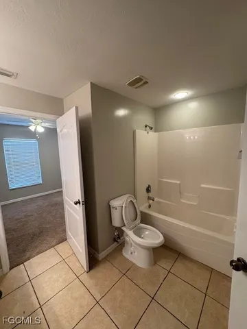 a bathroom with a granite countertop bathtub shower and toilet