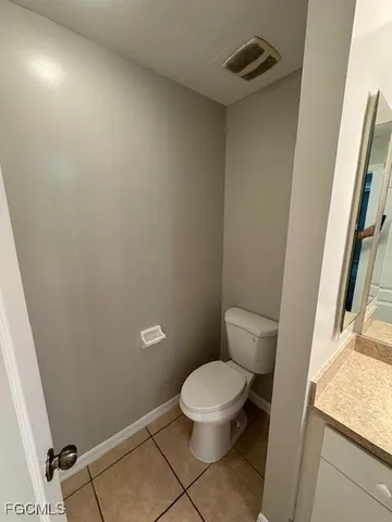 a white toilet sitting next to a sink and vanity