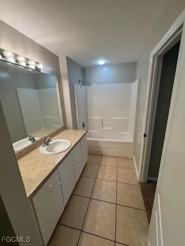 a bathroom with a granite countertop sink a toilet a mirror and vanity