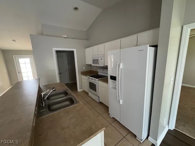 a kitchen with a refrigerator a stove top oven a sink and dishwasher