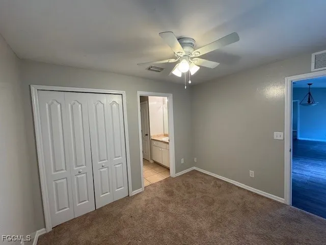 an empty room with closet and fan