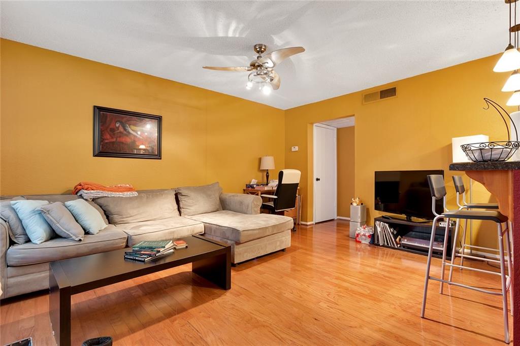 910 Duncan Lane, Unit 35 Austin, TX 78705 - Photo 1 of 20 Warm wood flooring extends throughout this inviting living space, providing a cohesive and polished foundation.